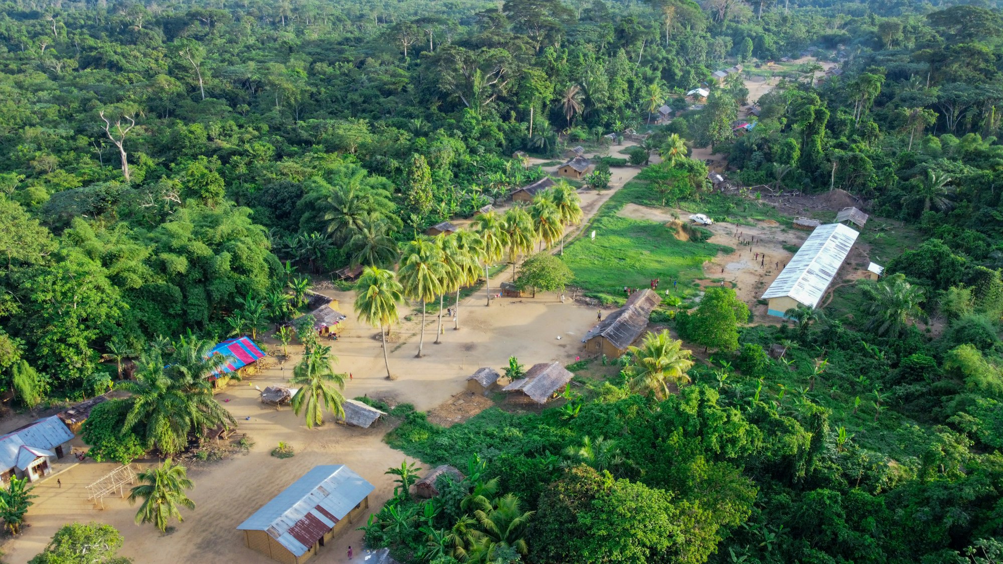 Vue aérienne d'un village et de la canopée de la forêt tropicale du Bassin du Congo